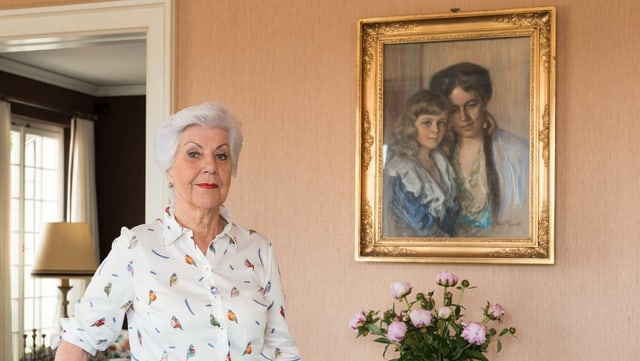Eine Frau vor dem Gemälde einer Mutter und ihres Sohnes. Eine Frau vor dem Gemälde einer Mutter und ihres Sohnes.