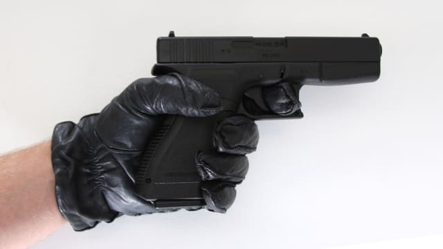 Eine kleine Waffe, von einer Hand gehalten. Eine kleine Waffe, von einer Hand gehalten.