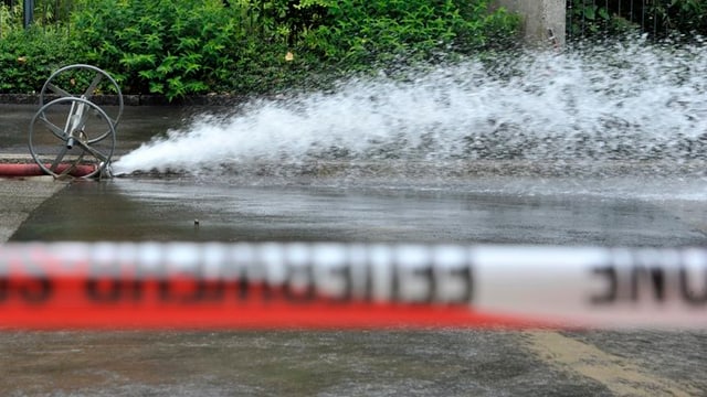 Wasser spritzt. Pfütze. Absperrband. Wasser spritzt. Pfütze. Absperrband.