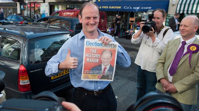 Douglas Carswell hält eine Zeitung in der Hand und streckt den Daumen hoch Douglas Carswell hält eine Zeitung in der Hand und streckt den Daumen hoch