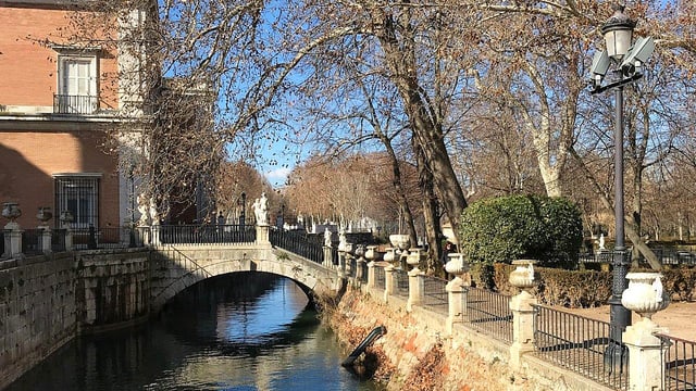 Der Schlossgarten in Aranjuez mit einem Wasserkanal und alten Bäumen daneben. Der Schlossgarten in Aranjuez mit einem Wasserkanal und alten Bäumen daneben.