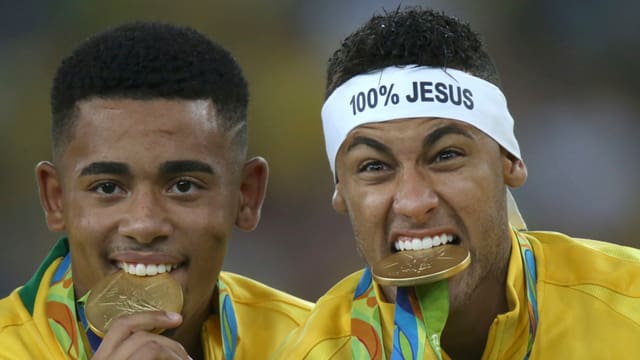 Neymar trägt Goldmedaille und ein Stirnband mit der Aufschrift 100 Prozent Jesus. Neymar trägt Goldmedaille und ein Stirnband mit der Aufschrift 100 Prozent Jesus.