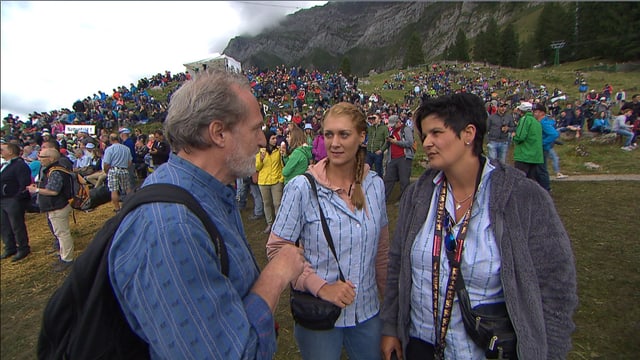 Ein Mann und zwei Frauen, ein Edelweiss-Hemd tragend Ein Mann und zwei Frauen, ein Edelweiss-Hemd tragend