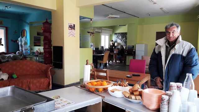 Ein Mann steht in einer improvisierten Kantine. Vor ihm liegt ein Frühstücksbuffet. Ein Mann steht in einer improvisierten Kantine. Vor ihm liegt ein Frühstücksbuffet.