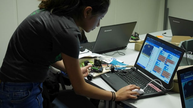 Ein Mädchen beugt sich über einen Laptop. Ein Mädchen beugt sich über einen Laptop.