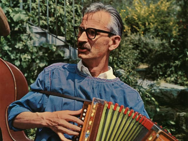 Mann mit graumeliertem Haar und Schnauzbart spielt Schwyzerörgeli. Mann mit graumeliertem Haar und Schnauzbart spielt Schwyzerörgeli.