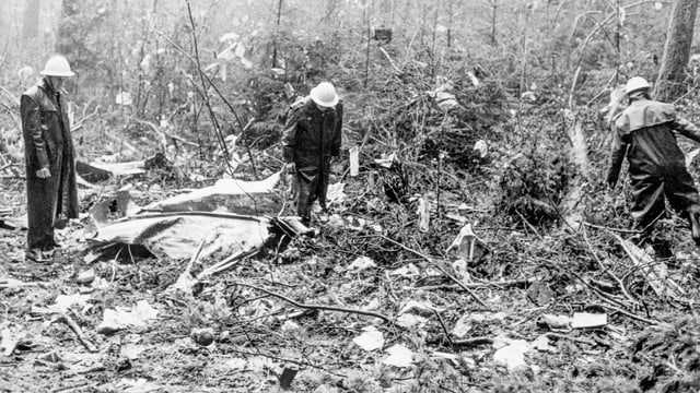 Schwarzweissfotografie. Polizisten im Wald. Trümmerteile am Boden. Schwarzweissfotografie. Polizisten im Wald. Trümmerteile am Boden.