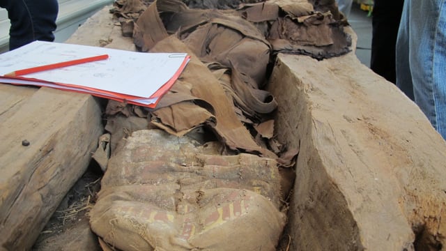 Geöffneter Sarkophag mit Überresten der Verbände