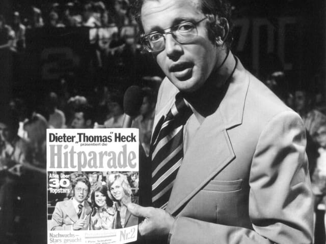 Moderator vor Life-Publikum hält Schallplatte in der Hand. Moderator vor Life-Publikum hält Schallplatte in der Hand.
