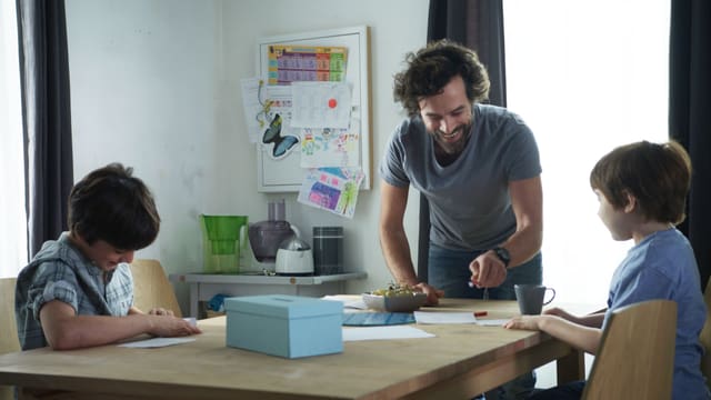 Mann mit zwei Kindern am Tisch Mann mit zwei Kindern am Tisch