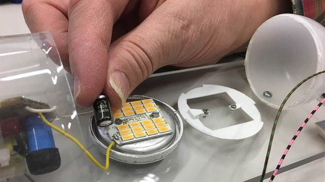 Mann zeigt Elektrobauteil Mann zeigt Elektrobauteil