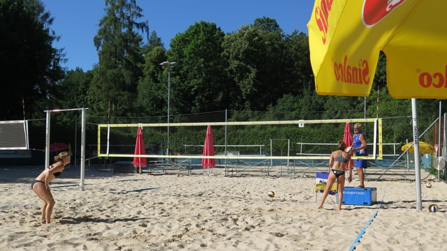 Ein Beachfeld und Spielerinnen Ein Beachfeld und Spielerinnen