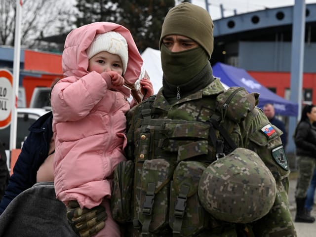 Soldat trägt Kind