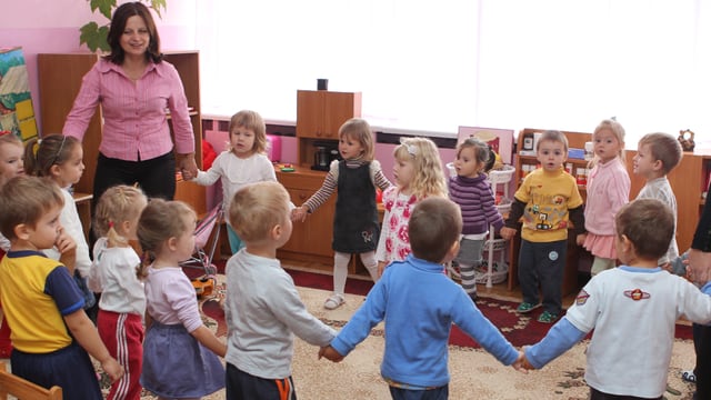 Eine Kindergartenklasse steht im Kreis. Eine Kindergartenklasse steht im Kreis.