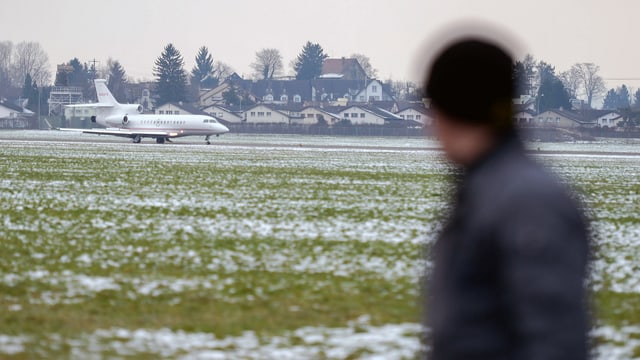 Mann schaut auf das grosse Areal des Flugplatzes Dübendorf Mann schaut auf das grosse Areal des Flugplatzes Dübendorf