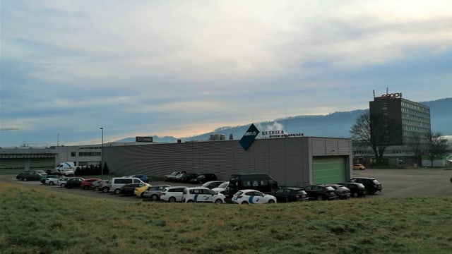 Garagenhalle, im Vordergrund Parkplatz, eingebettet in ein Industriegebiet Garagenhalle, im Vordergrund Parkplatz, eingebettet in ein Industriegebiet