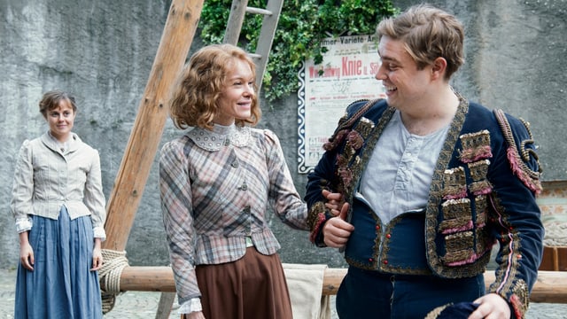 Margrit Lippuner (Mona Petri, Mitte) mit ihrem zukünftigen Mann Friedrich Knie (Simon Käser). Ihre Freundin Berta (Elisa Plüss, links) hat sie bekannt gemacht. Margrit Lippuner (Mona Petri, Mitte) mit ihrem zukünftigen Mann Friedrich Knie (Simon Käser). Ihre Freundin Berta (Elisa Plüss, links) hat sie bekannt gemacht.