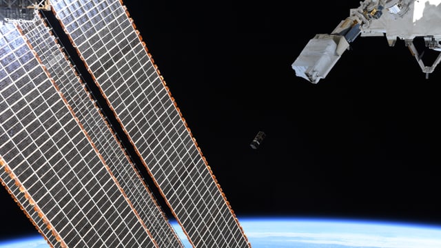 Nanosatellit im All mit SIcht auf Erde Nanosatellit im All mit SIcht auf Erde