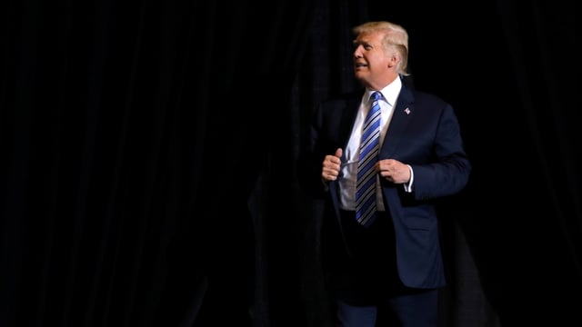 Trump aus der Ferne vor schwarzem Hintergrund. Trump aus der Ferne vor schwarzem Hintergrund.