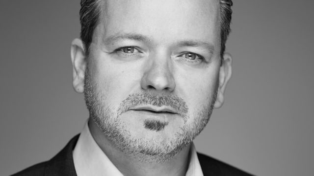 Schwarz-weiss Foto eines Mannes, der in die Kamera schaut. Schwarz-weiss Foto eines Mannes, der in die Kamera schaut.
