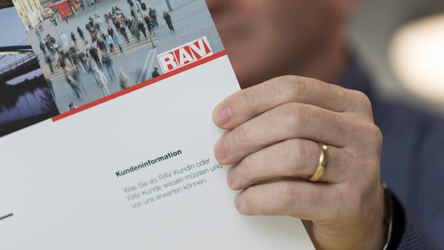 Ein Mann hält eine Broschüre des RAV. Ein Mann hält eine Broschüre des RAV.