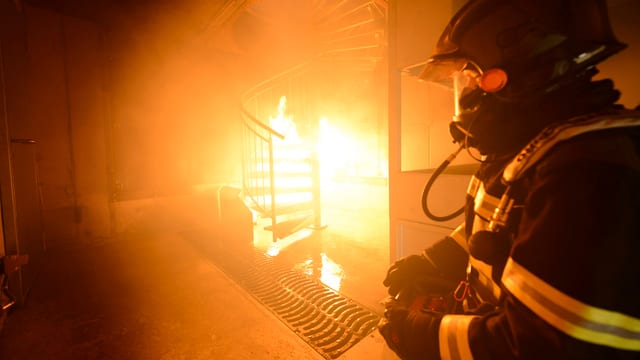 Feuerwehrmann mit Atemschutzgerät in brennendem Haus. Feuerwehrmann mit Atemschutzgerät in brennendem Haus.