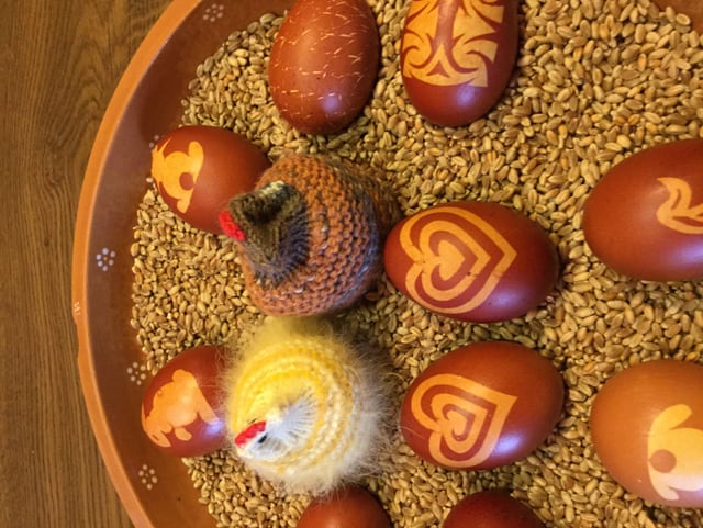Braune Ostereier mit Ornamenten und gestrickte Küken.