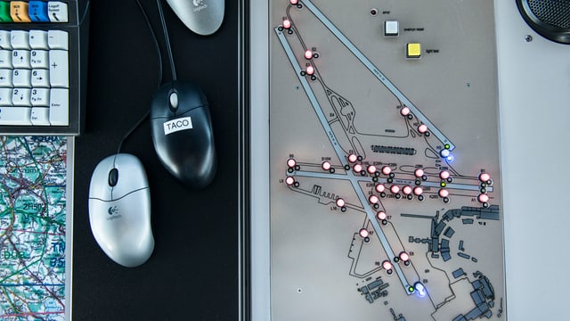 Drei Computermäuse, daneben ein Plan des Flughafens Kloten mit Lichtern. Drei Computermäuse, daneben ein Plan des Flughafens Kloten mit Lichtern.