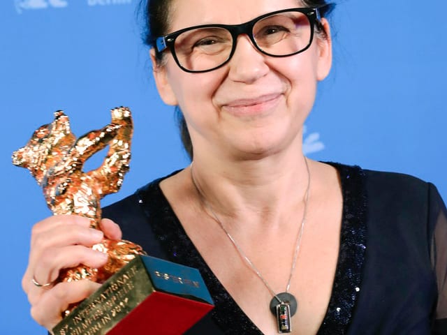 Porträt Ildikó Eneydi mit einer Trophäe, die einen goldenen Bären darstellt. Porträt Ildikó Eneydi mit einer Trophäe, die einen goldenen Bären darstellt.