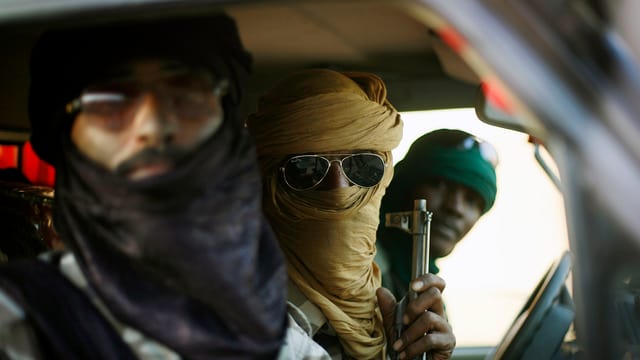 Drei bewaffnete Tuareg in einem Auto. Drei bewaffnete Tuareg in einem Auto.
