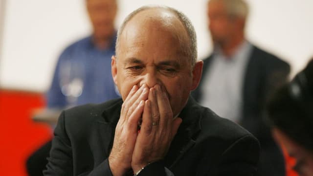 Ueli Maurer hat die Hände vor dem Mund und blickt überrascht und enttäuscht zu Boden. Ueli Maurer hat die Hände vor dem Mund und blickt überrascht und enttäuscht zu Boden.