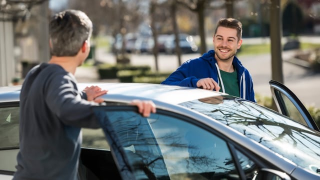Zwei Männer steigen gemeinsam in ein Auto Zwei Männer steigen gemeinsam in ein Auto