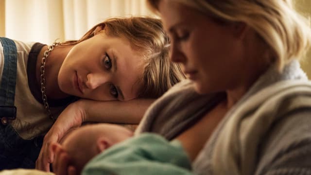 Zwei Frauen und ein Baby sitzen auf dem Sofa Zwei Frauen und ein Baby sitzen auf dem Sofa