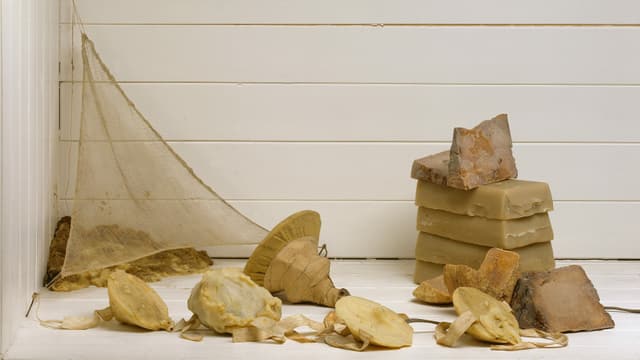 Ein paar Steine und Wachs vor einer weissen Holzwand. Ein paar Steine und Wachs vor einer weissen Holzwand.