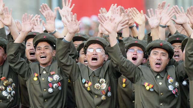 Uniformierte Soldaten winken begeistert. Uniformierte Soldaten winken begeistert.