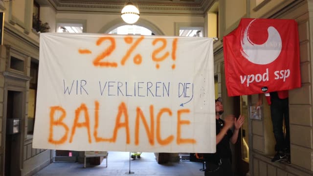 Ein weisses Transparent mit der Aufrschrift:« -2%?! Wir verlieren die Balance» Ein weisses Transparent mit der Aufrschrift:« -2%?! Wir verlieren die Balance»
