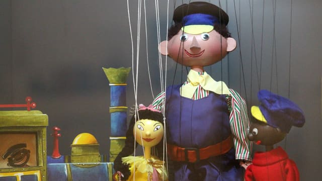 eine weibliche und zwei männliche Puppen, die einander umarmen eine weibliche und zwei männliche Puppen, die einander umarmen