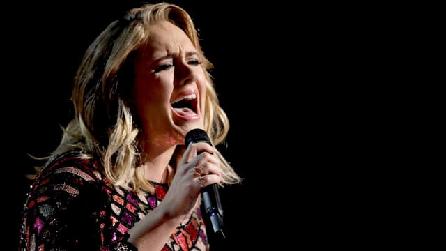 Adele singt mit schmerzverzerrtem Gesicht ins Mikrofon. Adele singt mit schmerzverzerrtem Gesicht ins Mikrofon.