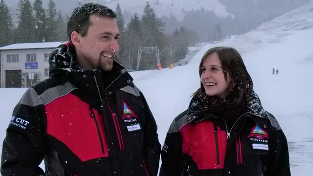 Zwei Personen lachen, während Schnee fällt. Zwei Personen lachen, während Schnee fällt.