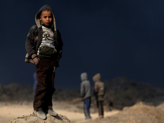 Kinder in Mosul vor brennenden Ölfeldern. Kinder in Mosul vor brennenden Ölfeldern.