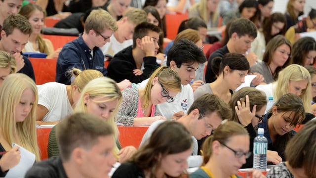 Viele Studierende sitzen in einem Hörsaal. Viele Studierende sitzen in einem Hörsaal.