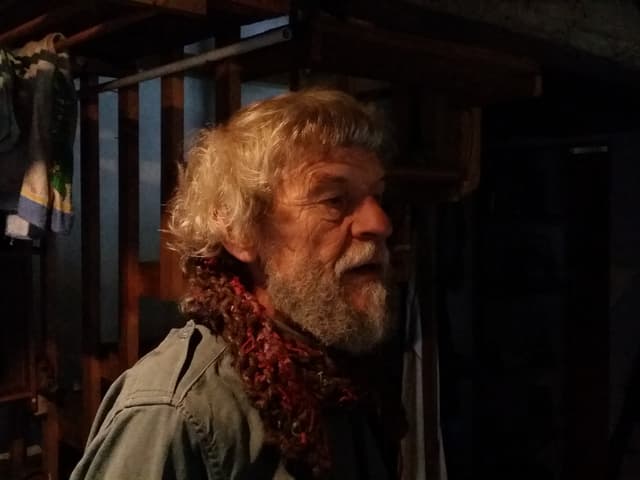 Ulrico Stamani trägt graues langes Haar mit Locken und einen grauen Bart.