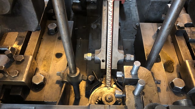 Nägel laufen in einer Maschine auf ein Verteilmechanismus zu. Nägel laufen in einer Maschine auf ein Verteilmechanismus zu.