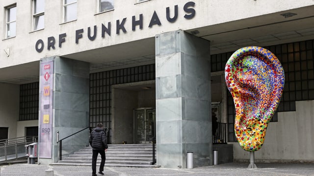 Eingang des Funkhauses mit einer grossen, farbigen-Ohr-Skulptur. Eingang des Funkhauses mit einer grossen, farbigen-Ohr-Skulptur.
