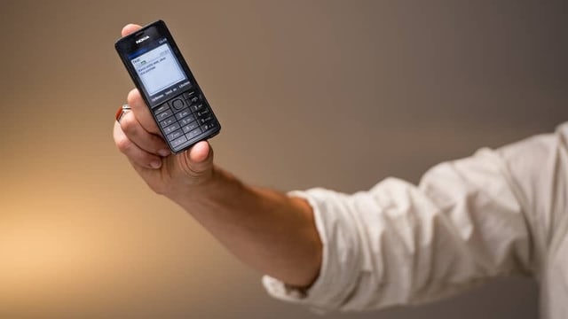 Ein Mann hält ein Nokia Telefon in der Hand. Ein Mann hält ein Nokia Telefon in der Hand.