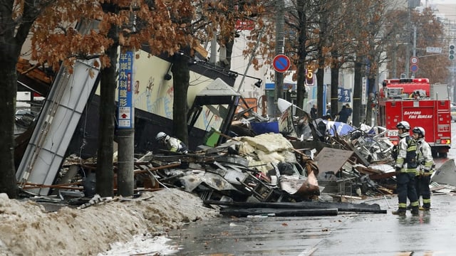 Feuerwehrleute vor Brandruine Feuerwehrleute vor Brandruine