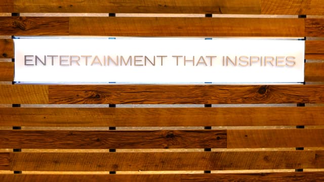 Das Schild mit der Aufschrift Entertainment that inspires hängt an einer Wand. Das Schild mit der Aufschrift Entertainment that inspires hängt an einer Wand.