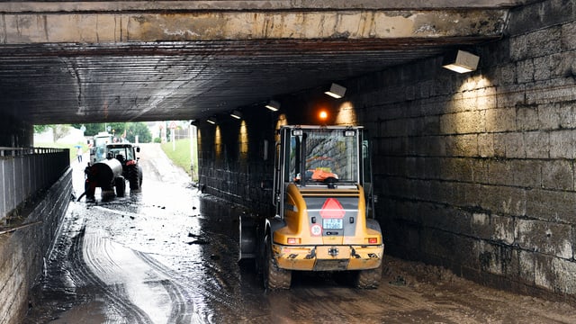 Bagger in überschwemmter Unterführung. Bagger in überschwemmter Unterführung.