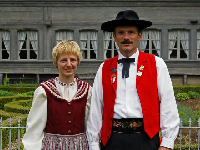 Trachtenpaar vor Bauernhof. Trachtenpaar vor Bauernhof.