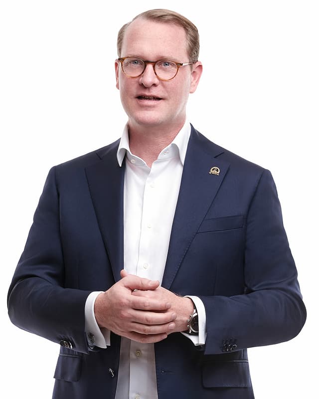 Hanspeter Vochezer im offenen weissen Hemd und Jackett. Hanspeter Vochezer im offenen weissen Hemd und Jackett.
